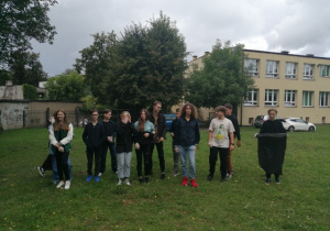 Na zdjęciu widzć uczniów na szkolnym boisku, którzy biorą udział w akcji "Sprzątanie Świata".