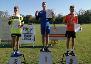 Na zdjęciu widać stojących na podium nagrodzonych uczestników zawodów.