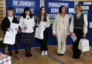 Na zdjęciu widać stojących laureatów konkursów wraz z opekunami.