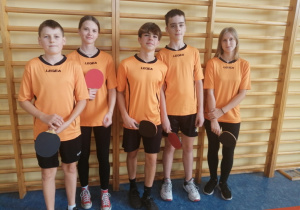 Na zdjęciu stoją uczniowie naszej szkoły uczestniczący w Powiatowych Igrzyskach Młodzieży Szkolnej w tenisie stołowym.