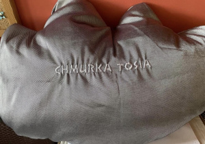 Na zdjęciu poduszka w kształcie chmurki z napisem "Chmurka Tosia".