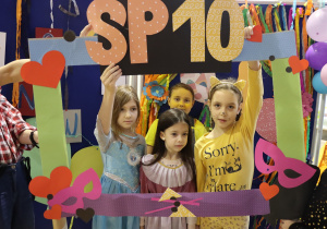 Uczniowie przebrani w stroje postaci bajkowych prezentują sie na tle napisu SP10.