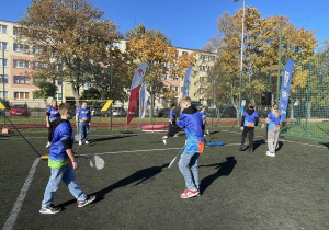 Na zdjęciu widzć uczestników gier sportowych podczas wykonywania zadań - gra w badmingtona.