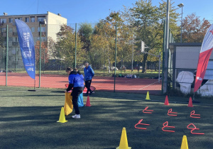 Na zdjęciu widzć uczestników gier sportowych podczas wykonywania zadań - pokonywanie toru przeszkód.