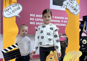 Odwiedzający szkołę goście pozują do zdjęć w fotobudce.