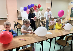Dzieci ozdabiają kolorowe balony.