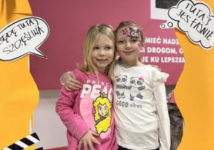 Odwiedzający szkołę goście pozują do zdjęć w fotobudce.