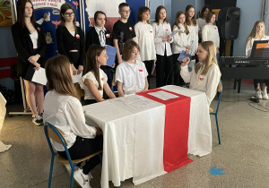 Na zdjęciu uczniowie w scence rodzajowej prezentują okoliczności uchwalenia Konstytucji 3 maja.