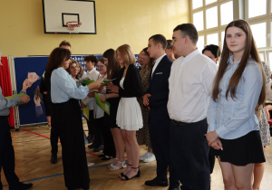 Na zdjęciu uczniowie klas ósmych, dyrekcja i wychowawcy podczas wręczania świadectw.