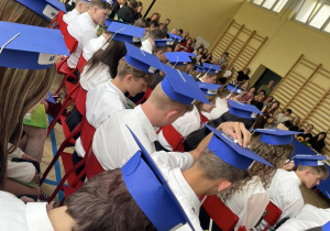 Absolwenci klas ósmych w czapkach absolwenta.