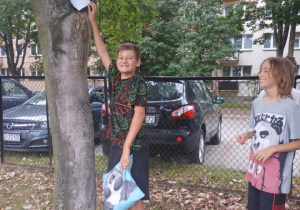 Na zdjęciu stoją uczestnicy gry podczas wykonywania zadania.