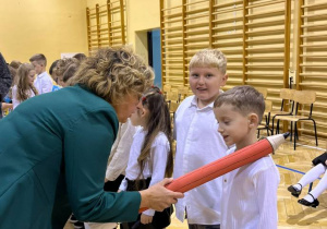 Na zdjęciu uczniowie oraz Pani Dyrektor Katarzyna Pasternak, która dokonuje pasowania.