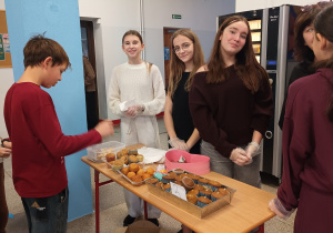Na zdjęciu uczniowie na szkolnym holu przy stoiskach z wróżbami.