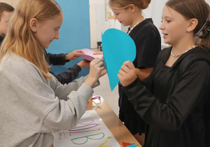 Na zdjęciu uczniowie na szkolnym holu przy stoiskach z wróżbami.