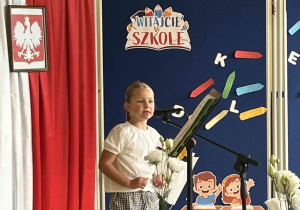 Na zdjęciu uczennica klasy 2b recytuje wiersz w części artystycznej spotkania.