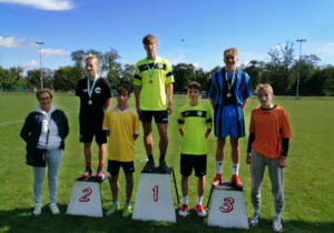 Nagrodzeni uczniowi stoją na podium.