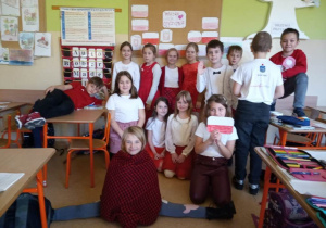 Uczniowie z klasy 1a stoją w pracowni ubrani w stroje biało - czerwone.