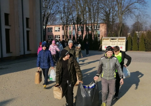 Na zdjęciu widać uczniów, którzy idą, by przekazać zebrane dary do magazynu Caritas przy parafii św. Pawła w Zdunskiej Woli.