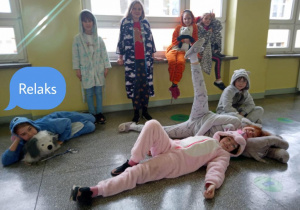 Uczniowie z klas młodszych pozują przebrani w piżamy na szkolnym korytażu