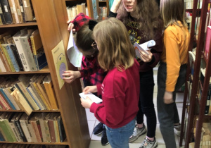 Na zdjęciu widać uczniów z kl. 5a w pomieszczeniach Biblioteki Pedagogicznej, którzy wykonują zadania w celu odnalezienia klucza do skarbu.