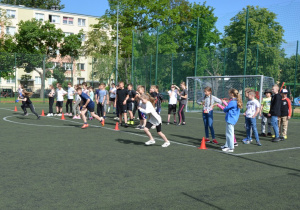 Na zdjęciu dzieci na szkolnym boisku podczas konkurencji sportowych.