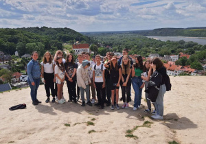 Na zdjęciu widać uczestników wycieczki stojących na Wzgórzu Trzech Krzyży. W dole panorama Kazimierza Dolnego.