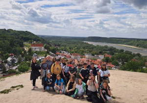 Na zdjęciu widać uczestników wycieczki stojących na Wzgórzu Trzech Krzyży. W dole panorama Kazimierza Dolnego.